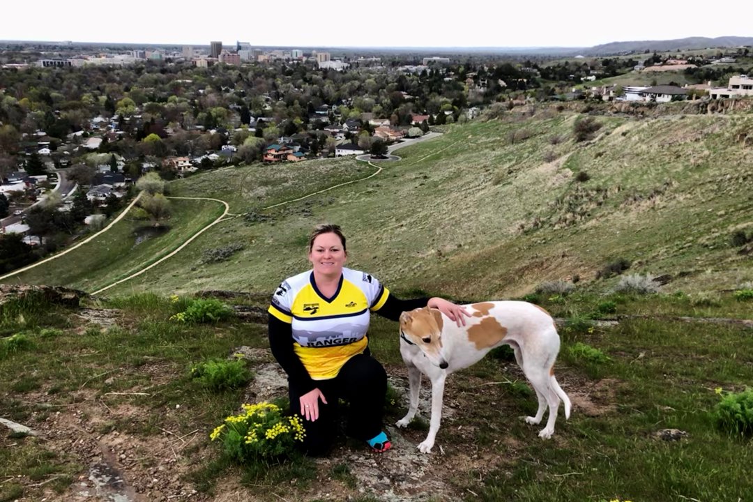 A Volunteer Trail Ranger and dog on a hill overlooking the Ridge to Rivers trail system.